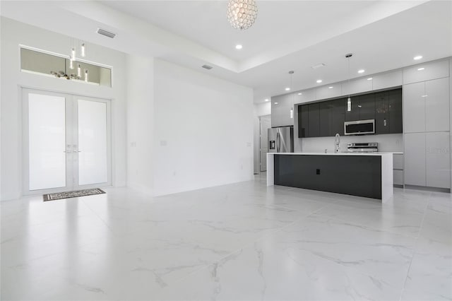 living room featuring french doors, a chandelier, and sink