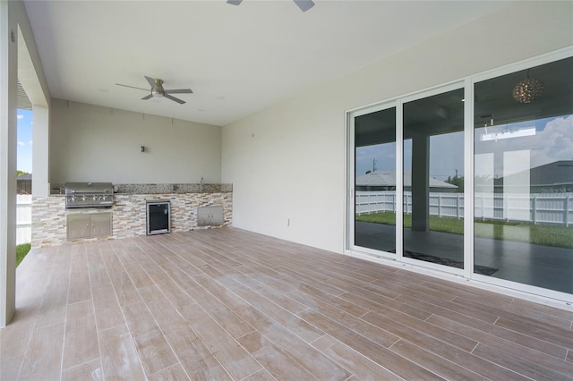 view of patio / terrace with grilling area, an outdoor kitchen, beverage cooler, and ceiling fan