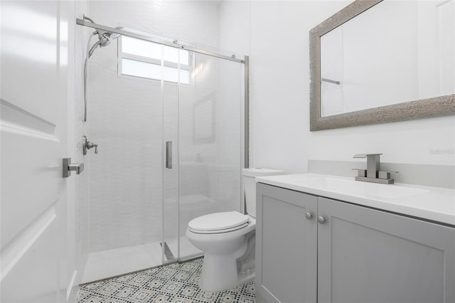 bathroom featuring vanity, an enclosed shower, and toilet