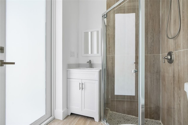 bathroom featuring vanity, wood-type flooring, and walk in shower