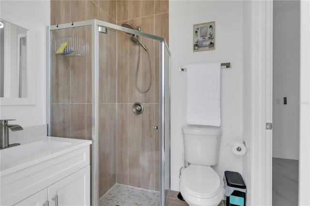 bathroom featuring vanity, toilet, and a shower with shower door