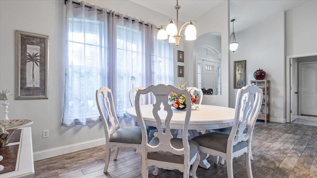 dining space with hardwood / wood-style floors and a chandelier