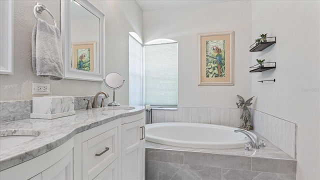 bathroom with tiled bath and vanity