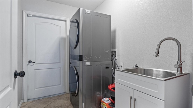 laundry area with cabinets, stacked washing maching and dryer, and light tile patterned flooring