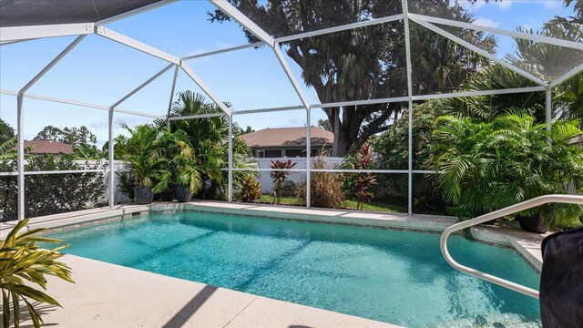 view of swimming pool featuring glass enclosure and a patio