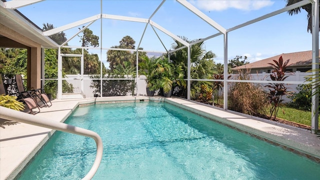 view of swimming pool featuring glass enclosure and a patio area