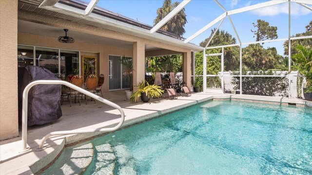 view of swimming pool with glass enclosure and a patio