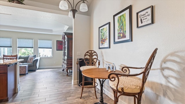 dining area with hardwood / wood-style floors, a textured ceiling, and a raised ceiling