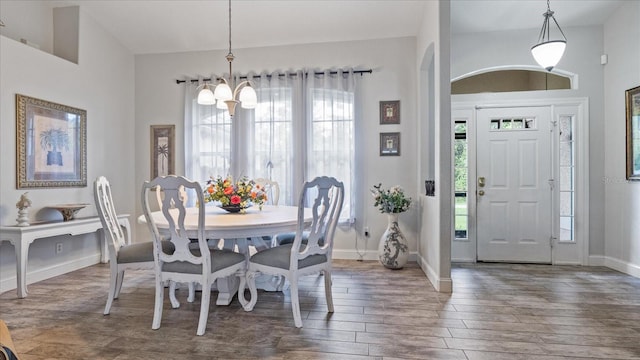 dining space with dark hardwood / wood-style floors and a notable chandelier