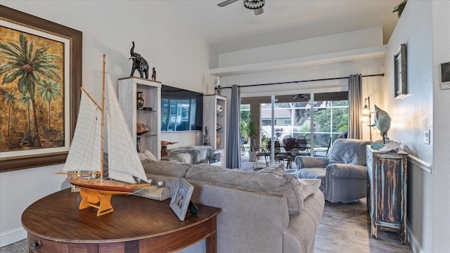 living room featuring hardwood / wood-style floors, vaulted ceiling, and ceiling fan