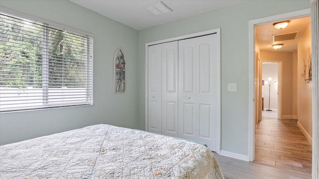 bedroom with light wood-type flooring and a closet