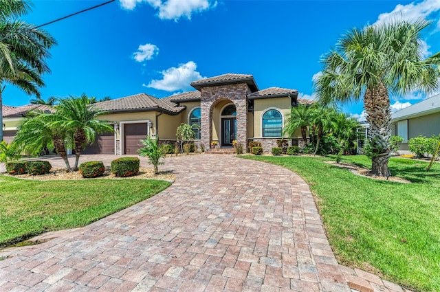 mediterranean / spanish-style home with a garage and a front yard