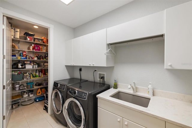 washroom featuring cabinets, sink, independent washer and dryer, and light tile patterned flooring