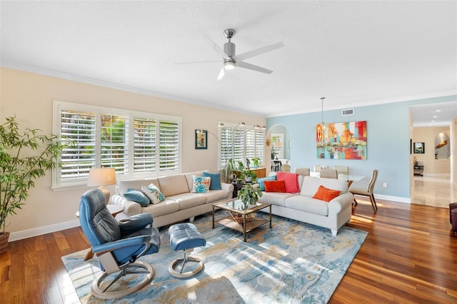 living room featuring crown molding, ceiling fan, and dark wood-type flooring