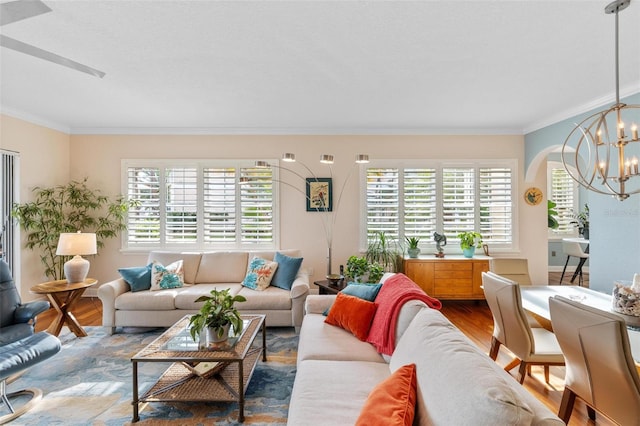 living room with a healthy amount of sunlight, wood-type flooring, and an inviting chandelier