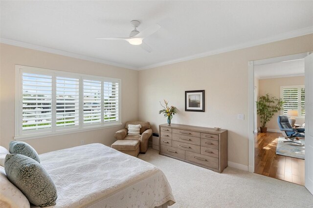 bedroom featuring light hardwood / wood-style flooring, ceiling fan, and crown molding