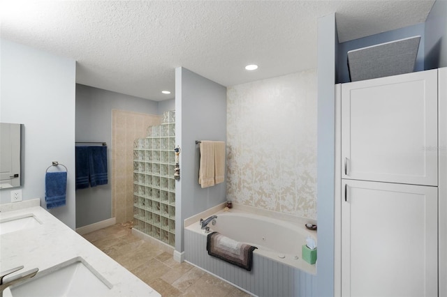 bathroom featuring independent shower and bath, a textured ceiling, and vanity