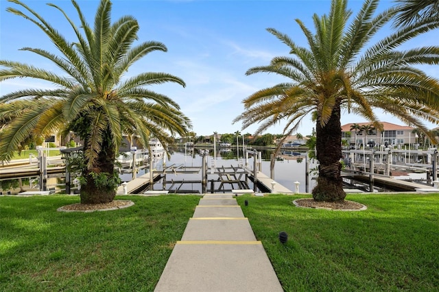 view of dock featuring a lawn and a water view