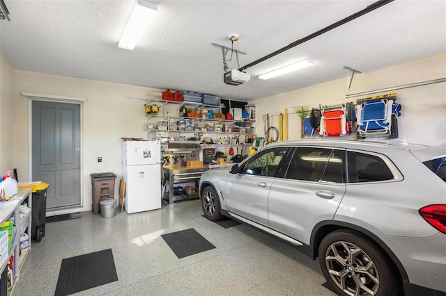 garage with a garage door opener, a workshop area, and white refrigerator