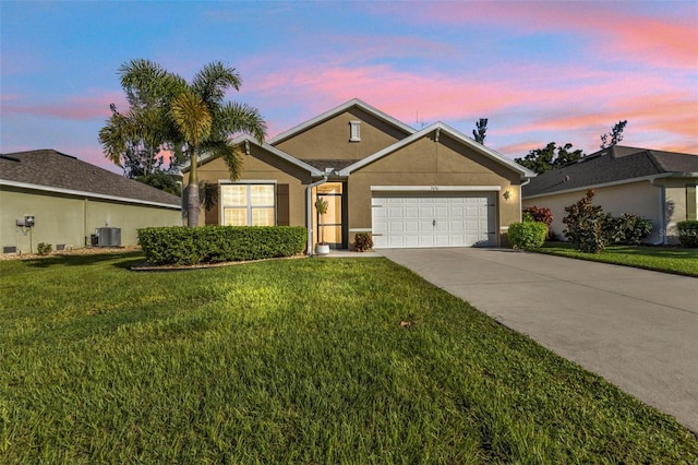 single story home featuring a lawn, a garage, and central AC unit