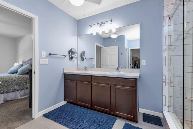 bathroom with tile patterned flooring, tiled shower, vanity, and ceiling fan