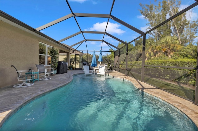 view of swimming pool featuring glass enclosure and a patio area