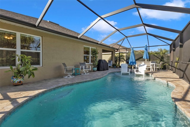 view of swimming pool featuring a lanai and a patio area