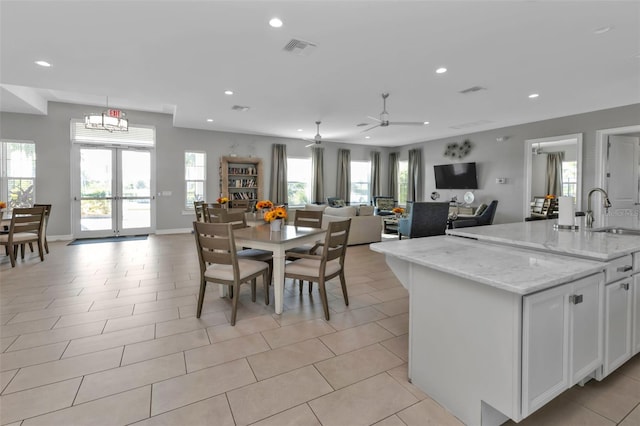 dining space with ceiling fan, sink, and light tile patterned floors