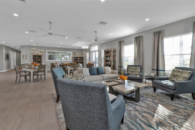 living room with ceiling fan with notable chandelier and light tile patterned floors