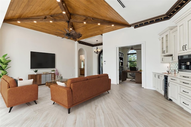 living room featuring light wood-type flooring, ceiling fan with notable chandelier, wood ceiling, and sink