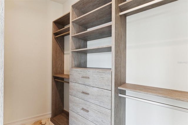 walk in closet with light hardwood / wood-style flooring