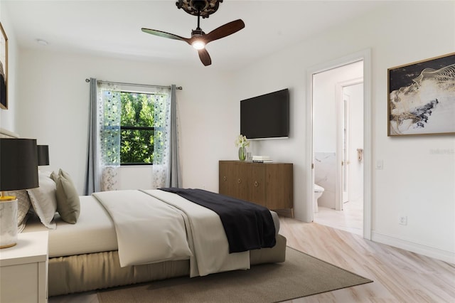 bedroom featuring light wood-type flooring, ensuite bath, and ceiling fan