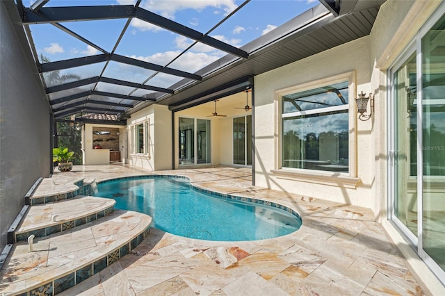 view of pool with ceiling fan, glass enclosure, and a patio area