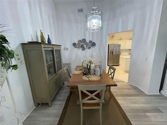 dining space featuring light hardwood / wood-style flooring and a notable chandelier