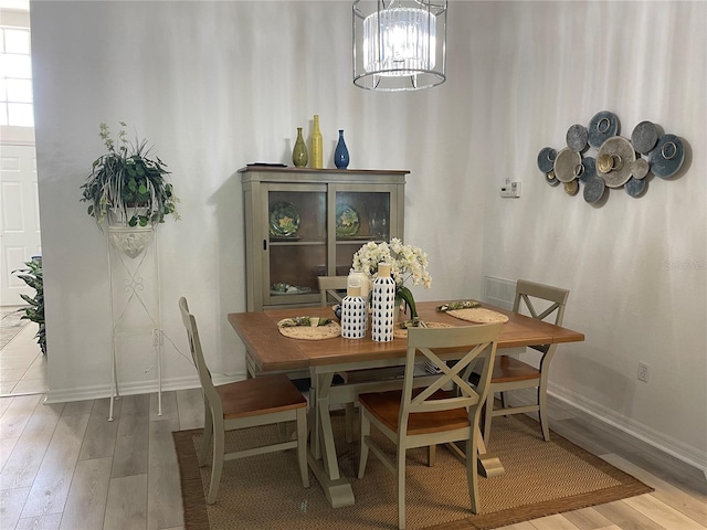 dining room featuring wood-type flooring and an inviting chandelier