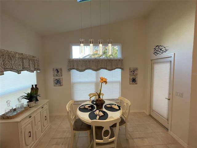 tiled dining area featuring vaulted ceiling