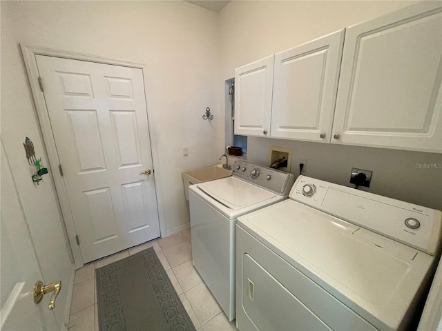 clothes washing area featuring cabinets, light tile patterned floors, separate washer and dryer, and sink