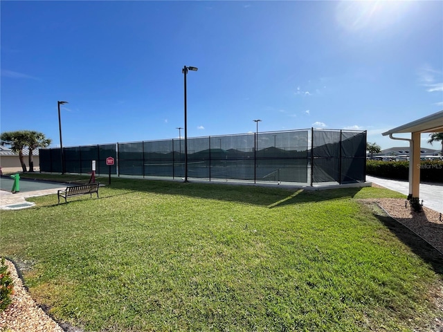 view of tennis court with a lawn