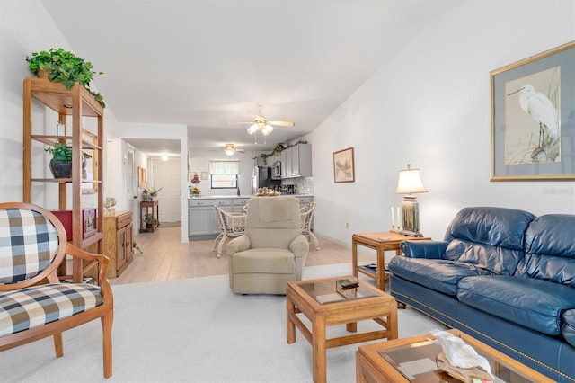 living room featuring ceiling fan and light hardwood / wood-style flooring