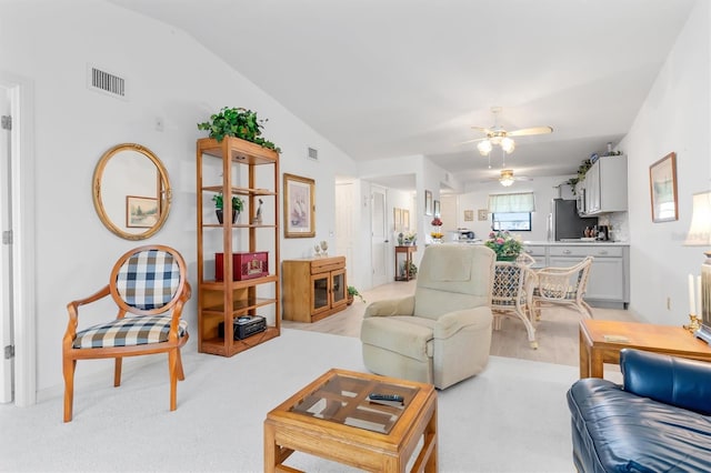 living room with ceiling fan, light colored carpet, and lofted ceiling