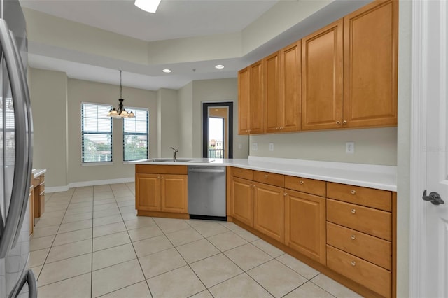 kitchen with kitchen peninsula, stainless steel appliances, sink, pendant lighting, and a chandelier