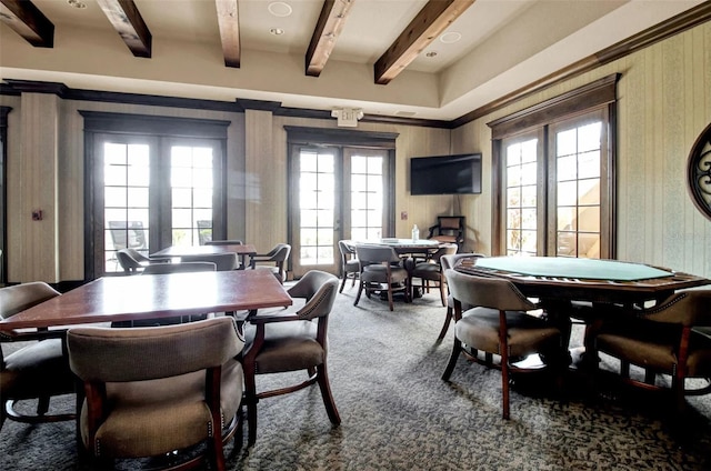 carpeted dining area featuring beamed ceiling and french doors