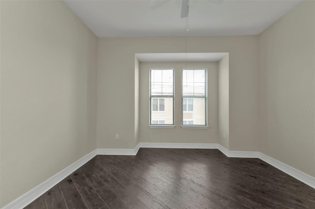 unfurnished room with ceiling fan and dark wood-type flooring