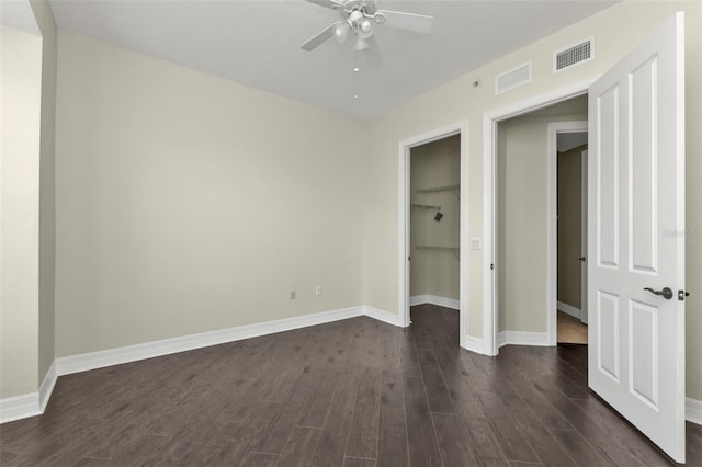 unfurnished bedroom with a closet, ceiling fan, and dark wood-type flooring