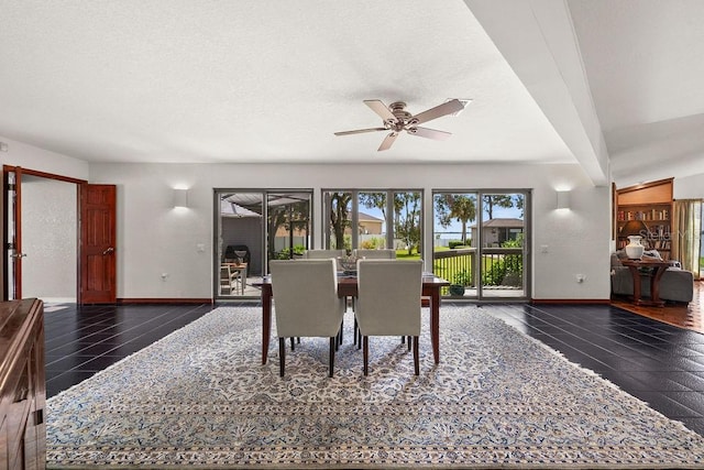 dining space with dark tile patterned flooring, ceiling fan, and vaulted ceiling