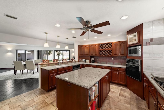 kitchen featuring pendant lighting, a center island, backsplash, kitchen peninsula, and stainless steel appliances