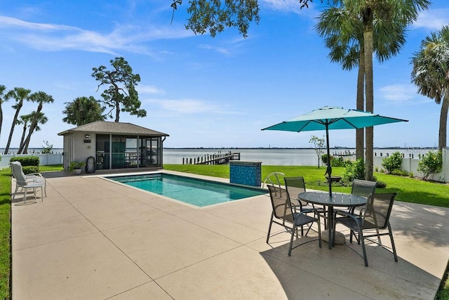 view of swimming pool with a yard, a water view, and a patio area