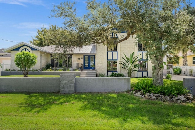 view of front of home featuring french doors and a front yard