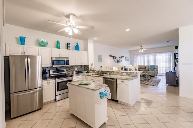 kitchen featuring kitchen peninsula, ceiling fan, stainless steel appliances, and white cabinets