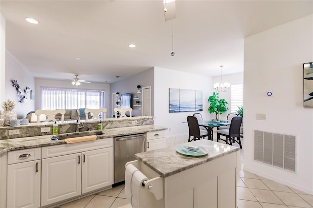 kitchen featuring white cabinetry, ceiling fan with notable chandelier, a center island, stainless steel dishwasher, and sink